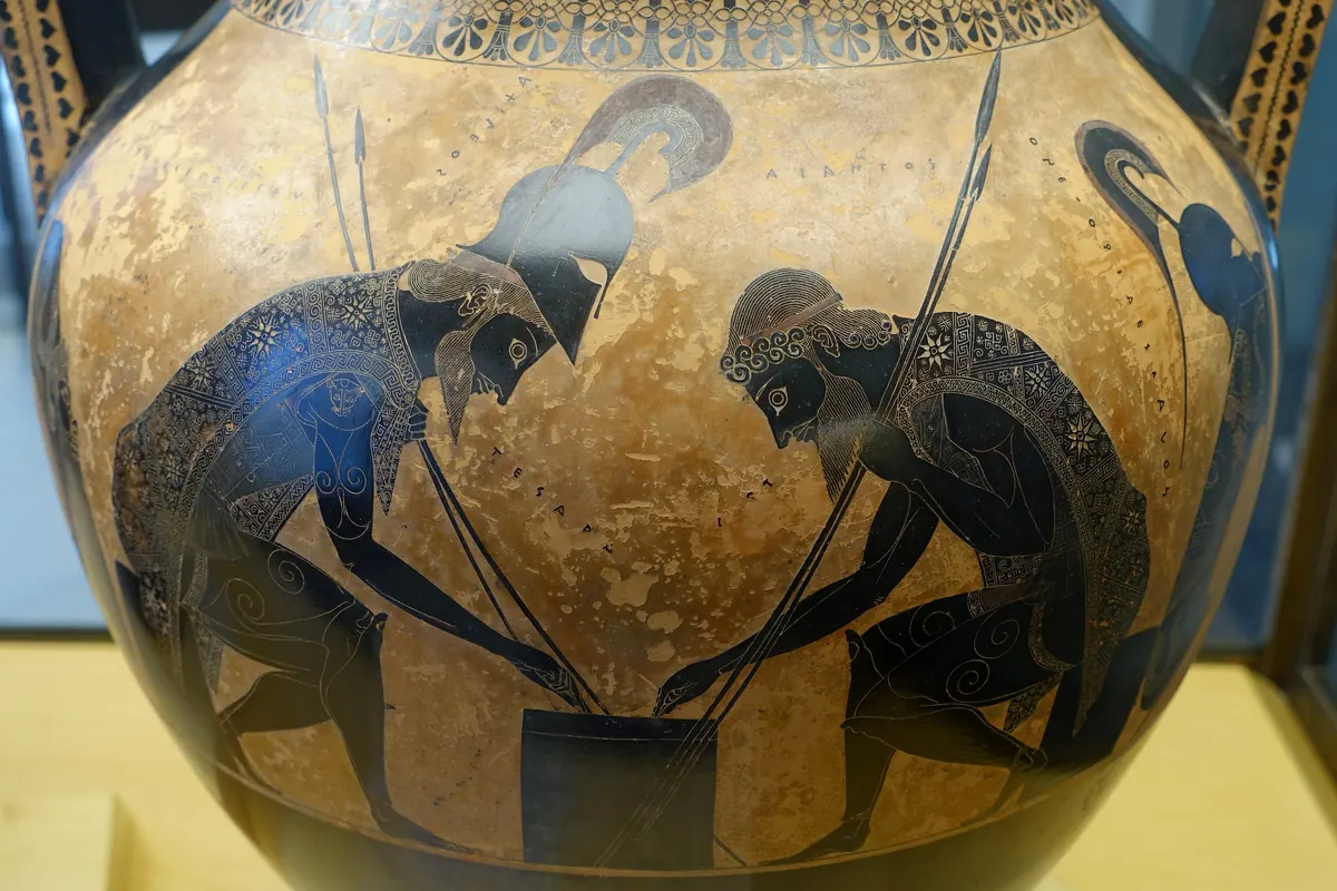 Two armoured warriors bend over a game on the orange panel of a Greek vase, with a museum case behind (Achilles and Ajax on an Athenian amphora in the Vatican Museums, not the show)